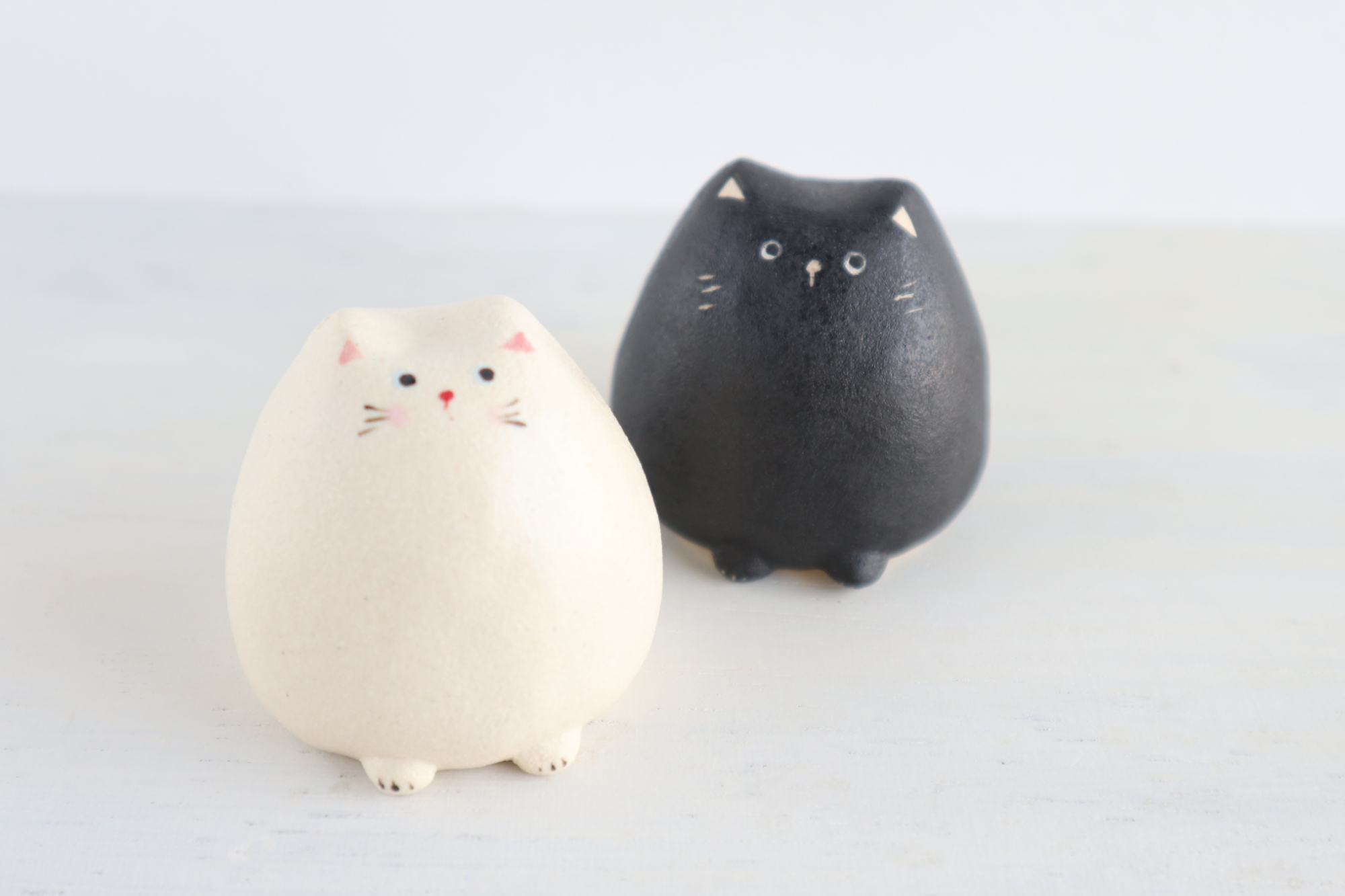 陶器の小さな猫の置物たち（白/黒）